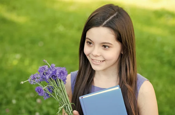 Little smart girl with book outdoors sunny day, childrens day concept — Stock fotografie