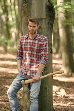 İşten sonra rahatla. Hafta sonunu ormanda piknik yaparak geçirmek. Adam baltayla odun kırmaya ve odun kesmeye hazır. Ağacı kesmeye hazırlanın. Yakacak odunları baltayla doğramak. Ormanda kereste işçisi