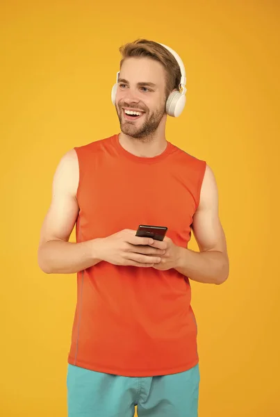 Inspiration for blogging. athletic guy in sportswear. new digital technology. happy young man in headphones. modern sport life. fitness mobile app. listen to music. sportsman use phone on workout — Stock Photo, Image