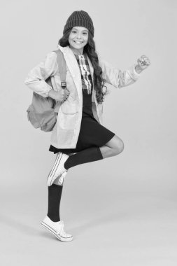 Moda aksesuarı olarak sırt çantası. Küçük, modaya uygun bir kız sırt çantası taşıyor. Günlük yaşam için modern sırt çantası. Gençlik modası. Şirin sırt çantalı okul kızı tarzı kıyafetler. Sırt çantasını düzgün tak