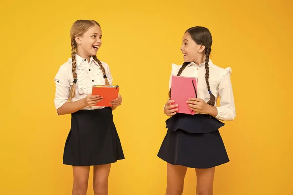 Vamos ler a sério. Meninas adoráveis segurando livros da biblioteca em fundo amarelo. Crianças pequenas bonitos aprendendo a ler na escola primária. Ler e alcançar — Fotografia de Stock