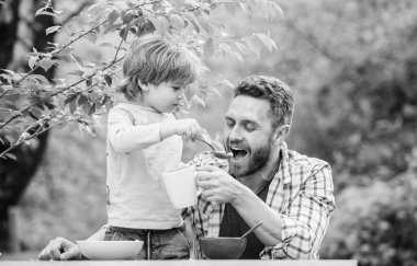 Aile ev yapımı yemeğin tadını çıkarır. Yemek alışkanlıkları. Babası yemek yiyen küçük bir çocuk. Yaz kahvaltısı. Sağlıklı gıda konsepti. Baba oğul yemek yer ve eğlenir. Bebeği besliyorum. Çocuklar için menü