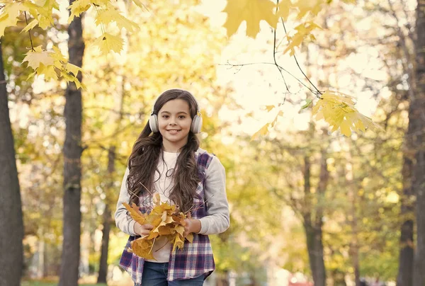 Naprosto šťastný. krása a příroda. Šťastné dítě nosí sluchátka. dospívající dívka poslouchat hudbu na cestě do školy. dětská procházka v podzimním lese. podzimní javorové listy v parku. online vzdělávání. štěstí v dětství — Stock fotografie