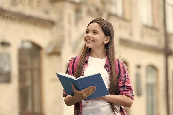 Wyobraźnia i kreatywność jednocześnie. Szczęśliwe dziecko trzymać książkę z zamyślonym wyglądem. Edukacja szkolna. Fantazja i pomysłowe myślenie. Wiedza i informacje. Wyobraźnia nie ma ograniczeń, przestrzeń kopiowania — Zdjęcie stockowe