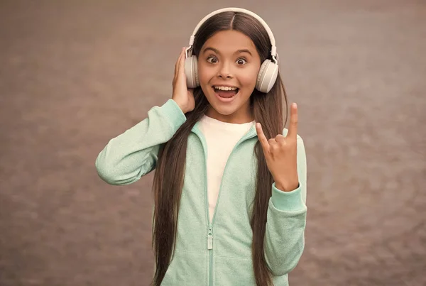 Divertido niño de la escuela escuchar música o audio libro en auriculares para la educación y la alegría, la vida moderna y la diversión — Foto de Stock