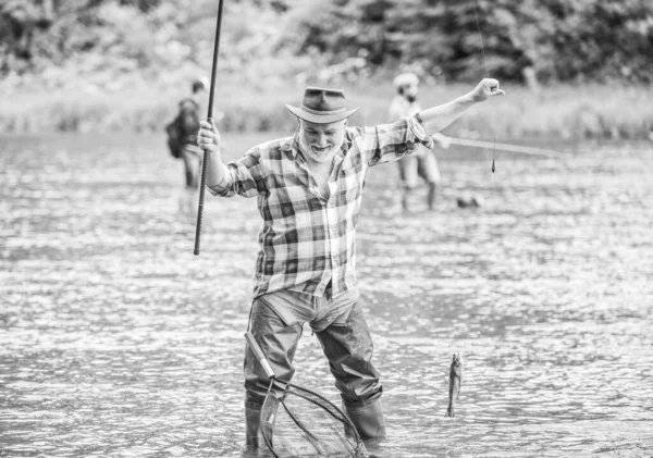 Vita piena di nuovi hobby. weekend estivo. pescatore con canna da pesca. uomo maturo pesca. Pescatore barbuto in pensione. pesca d'altura. pothunter. uomo cattura il pesce. attività sportiva e hobby. Esche di trota — Foto Stock