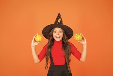 Cadılar Bayramı için cadılar bayramı şapkalı komik çocuk ya da turuncu arka planda kabak, Jack O Lantern.