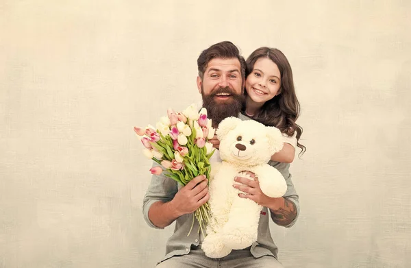 パパと女の子の子供抱擁ともに春チューリップ花束とテディベアおもちゃ幸せな家族 — ストック写真