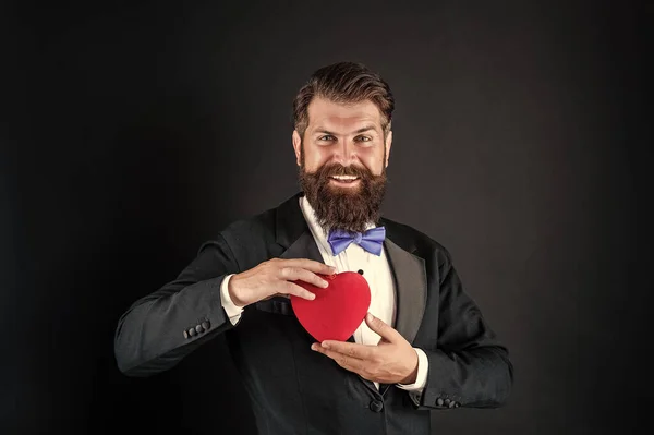 Homem barbudo em smoking formal com laço compartilhar coração amor no dia 14 de fevereiro dia dos namorados, amor — Fotografia de Stock