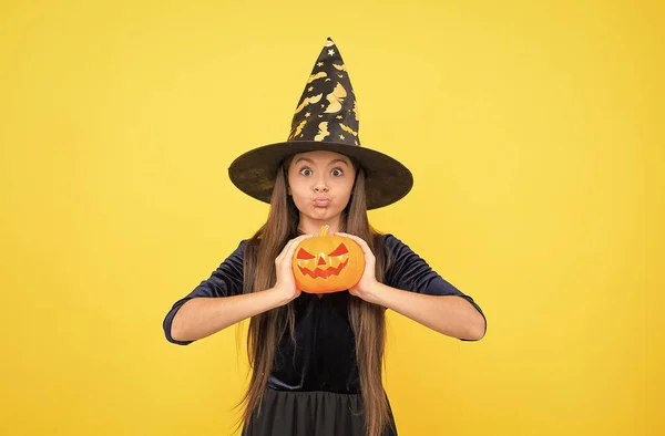 Demoness. jack o lantern. happy halloween. child in witch hat. kid hold spooky pumpkin. witchcraft and enchantment. childhood autumn holiday. teen girl ready to celebrate. costume party fun — Stock Photo, Image