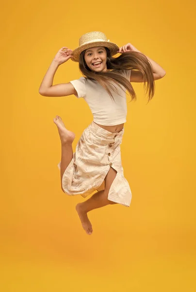 Happy barefoot child jump. carefree childhood happiness. small girl wear summer outfit. summer vacation fashion. happy childrens day. having fun on beach party. kid in straw hat — Stock Photo, Image