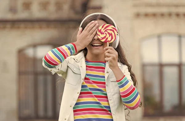 Девушки беспроводные наушники едят конфеты леденцы, слепой выбор концепции — стоковое фото