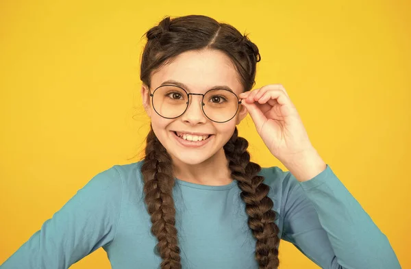 Να φοράει αλεξίσφαιρο. Έξυπνο παιδί. Ομορφιά με γυαλιά. Παιδική ευτυχία. Το χαμογελαστό παιδί φοράει γυαλιά εξαιτίας της κακής όρασης. Τρίχες πλεγμένες με κοτσίδες. ευτυχισμένη έφηβη κοπέλα με κομψό χτένισμα — Φωτογραφία Αρχείου