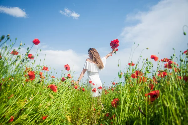 Feeling herself carefree. beautiful lady among poppies. opium. happy girl gathering spring bouquet. — Stock Photo, Image