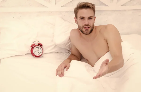 Homem cama de dormir roupas de cama brancas e despertador vermelho, conceito de despertar matutino — Fotografia de Stock