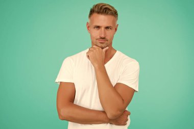 Son moda saç stili ile gülümseyen adam gri saçlı ve turkuaz arka planda bakımlı bir yüze sahip, kuaför