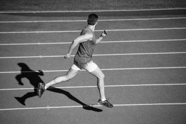 Spor giyim sektöründeki sporcu adam hızlı koşuyor koşu pistinde koşuyor, dayanıklı.