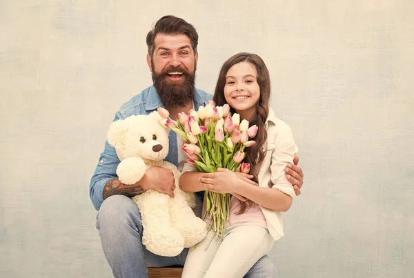 Papá y niña abrazo del niño con el ramo de flores de tulipán de primavera y el juguete del oso de peluche, día de los niños — Foto de Stock