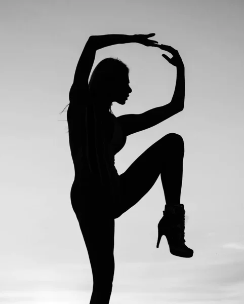 Female silhouette on sunset sky background of dancing woman, silhouette Royalty Free Stock Images