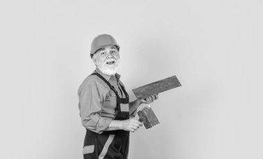 sarı alçıpanlı alçıpanlı alçıpan spatulası. Üniformalı sıvacı. Spatulalı adam. Macun katmanının uygulanması işlemi. Sıva için alçı araçları