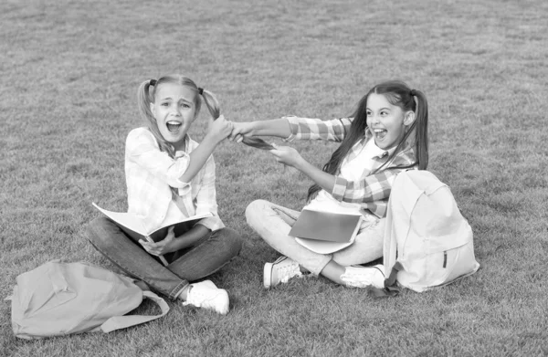 Dívky školní žáci dělat domácí úkoly společně na čerstvém vzduchu, sestry rivalita koncept — Stock fotografie