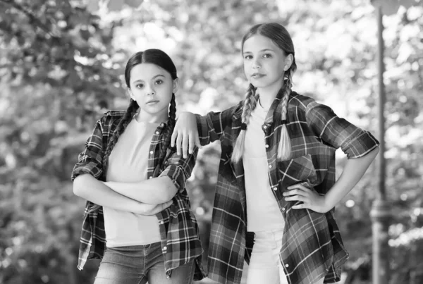 Belas pupilas. Roupa de hipsters casuais. retrato de irmãs felizes. Miúdos, raparigas de camisa. Duas jovens garotas hipster sorridentes em roupas de verão na moda. crianças despreocupadas posando ao ar livre. Modelos positivos — Fotografia de Stock