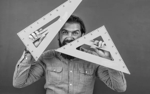 Homem com barba e bigode olhar como homem de negócios ou professor na faculdade ou escola, ferramenta triângulo — Fotografia de Stock