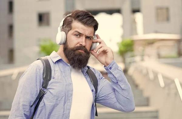 Live life loud with headphones. Hipster wear headphones outdoors. Bearded man listen to music in headphones. New technology. Modern life. Headphones for listening closely — Stock Photo, Image