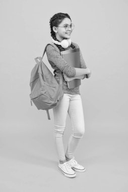 Sırt çantası ve okul malzemeleri ile modern öğrenci kız sarı arka plan, bilgi günü konsepti