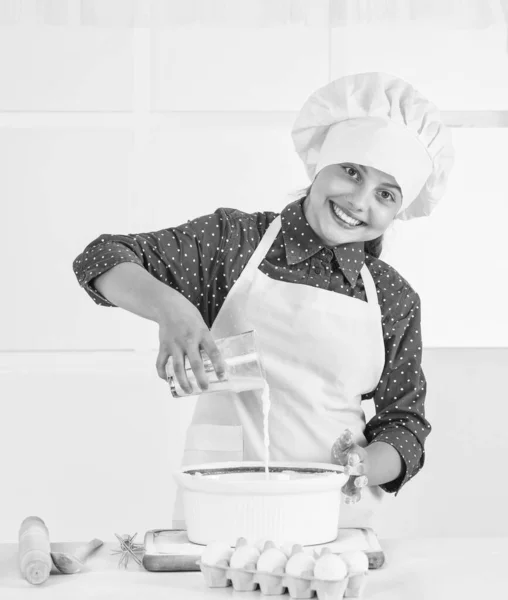 요리사 복장을 하고 요리하고 굽고 부엌에서 웃고 있는 10 대 소녀 — 스톡 사진