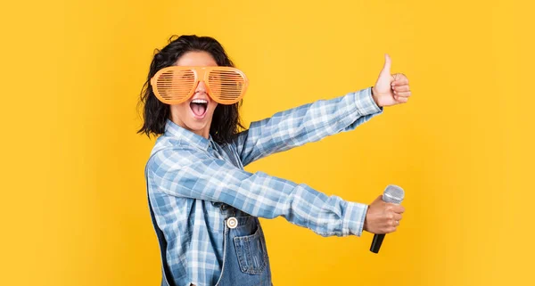 Hipster femenino sonriente con ropa de moda cantando en micrófono, gestor de eventos —  Fotos de Stock