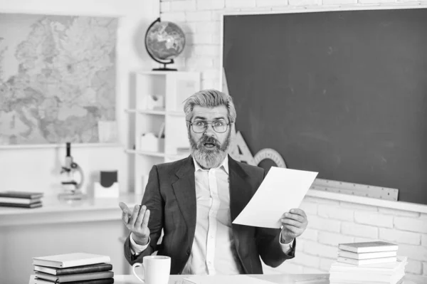 Educador inteligente e maduro. Dia do conhecimento. Professor de escola de homem sentar na sala de aula. Supervisionar professor monitor e apoio. Plano de aula. Documentos de papelada. TPC da escola. De volta à escola — Fotografia de Stock