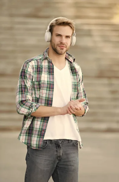 Hombre moderno escuchando música auriculares inalámbricos, camino al concepto universitario —  Fotos de Stock