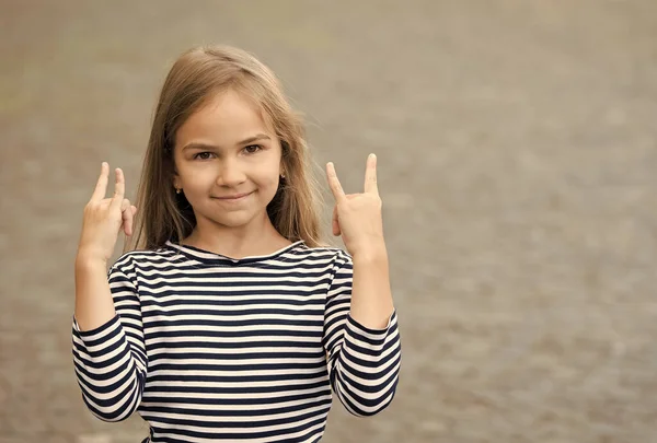 Feliz niño pequeño mostrar cuernos señales de mano con estilo de moda casual al aire libre, fresco, espacio de copia — Foto de Stock