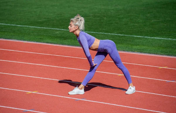 Sexy sportowe kobieta rozciąganie i rozgrzewka w sportowe odzież na stadionie bieżni toru, opieka zdrowotna — Zdjęcie stockowe