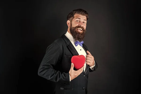 Homem barbudo em smoking formal com laço compartilhar coração amor no dia 14 de fevereiro dia dos namorados, amor — Fotografia de Stock