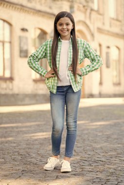 Sıradan bir bakış. Küçük çocuk ellerini açık havada tutuyor. Sıradan bir tarzı var. Modayı takip eden çocuklar giyer. Moda sokak kıyafetleri. Günlük giysiler. Konfordan ödün vermeden