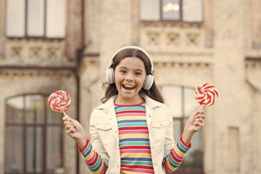 Sağlıklı bir yaşam tarzı. Lolipopu olan liseli kız. Kulaklıklı mutlu çocuk. Öğrenci müzik dinler ve şarkı söyler. Okula dönüyorum. Açık havada mutlu bir güzellik. Çocuk eğitimde yenilik yapıyor. Mutlu çocuklar günü. Mutluluk