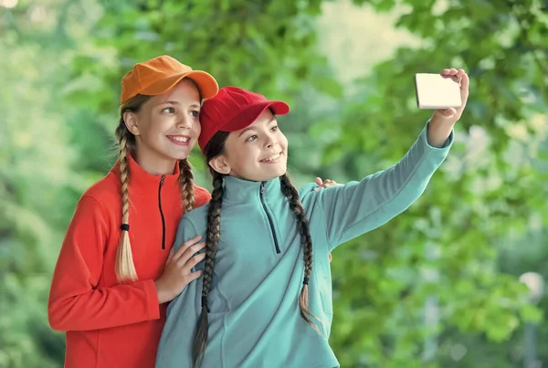 Happy girls with beauty look pose for selfie camera phone on natural landscape, self-portrait photos — Stock fotografie