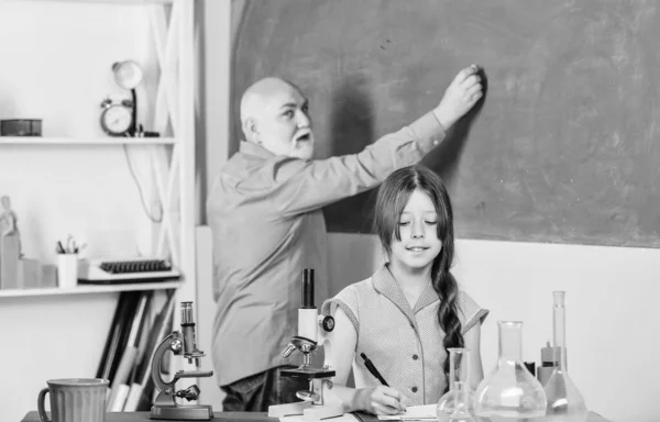 Εργαστήριο Επιστημών. Μικρό κορίτσι με δάσκαλο άντρα σπουδάζει χημεία. ώριμη καθηγήτρια βιολογίας. Μαθήτρια στο σχολικό εργαστήριο. τάξη της επιστήμης. Χρησιμοποιήστε μεγεθυντικό φακό. Μικροσκοπία. Εργαστηριακός εξοπλισμός — Φωτογραφία Αρχείου