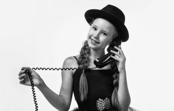 Ze luistert. nieuwe technologie. tiener meisje in hoed spreken over de telefoon. Retrofoon. Gelukkige jeugd. Hij heeft een telefoongesprek. communicatie in het moderne leven. kind met ouderwetse vintage telefoon — Stockfoto