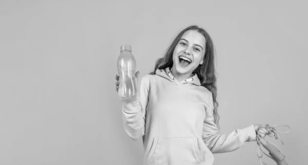 Menina sorridente feliz segurar esporte ou equipamento de fitness de corda de salto e garrafa de água, saúde — Fotografia de Stock