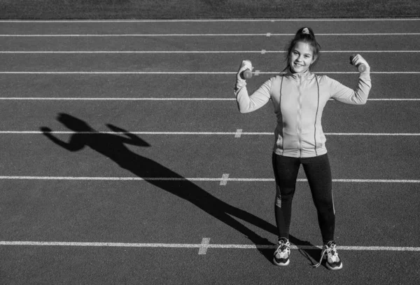 Ben en iyisiyim. Güç ve güç. Beden eğitimi dersinde çocuk eğitimi. Halterler. Elinde halter tutan genç bir kız. Spor salonu antrenmanı için hazırlanın. Stadyum spor salonunda ısınıyorum. — Stok fotoğraf