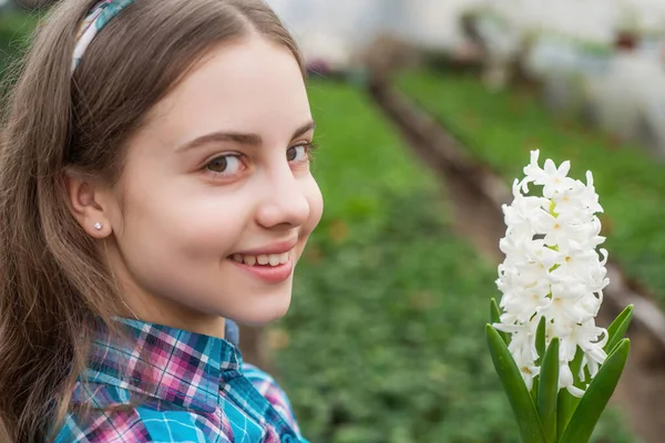 Glad tonåring flicka florist vård kruka växter i växthus, barndom — Stockfoto