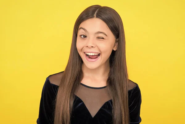 Happy little girl child smile winking with open mouth and showing healthy teeth yellow background, dentistry — Stock Photo, Image