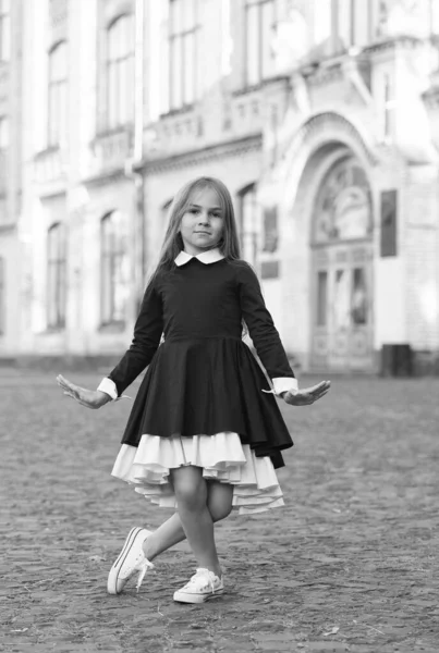 Söt liten dansflicka i skoluniform gör curtsy utomhus, dans — Stockfoto