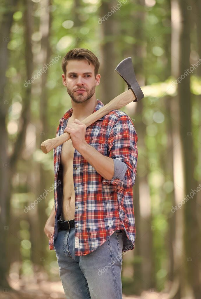 Mirada robusta. El hombre sin afeitar lleva hacha en el bosque. Estilo lenador. Axeman usa camisa