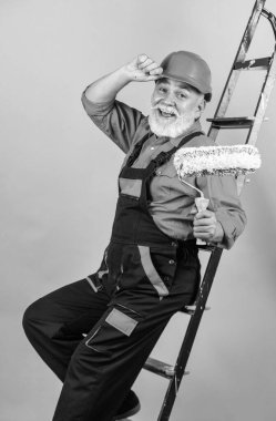 İnşaat mühendisi. Kıdemli boyacı merdivende paten kullanır. Duvarı yeşile boyuyorum. İş kıyafetleri içinde profesyonel bir ressam. Odada duvar boyama işçisi. Tekerlekli erkek dekoratör