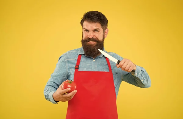 Galning man skära färsk tomat för att laga hälsosam ekologisk vegetarisk mat gul bakgrund, matlagning — Stockfoto