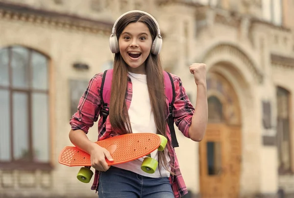 Un paseo activo. Happy girl skater flex arm holding penny board al aire libre. Deporte de acción. Actividad recreativa. Estilo de vida saludable. Patinaje callejero. Vacaciones de verano. Activo y enérgico — Foto de Stock